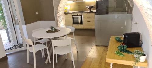 eine Küche mit einem weißen Tisch und weißen Stühlen in der Unterkunft BorgoAntico34 - Luxury Room in Molfetta