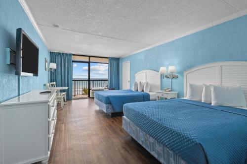 マートルビーチにあるNorth Shore Oceanfront Resort Hotelのベッド2台とテレビが備わるホテルルームです。