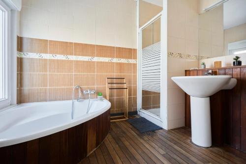 une salle de bain avec une baignoire et un lavabo dans l'établissement Locations Boulogne sur mer, 4 chambres, Tamaris, à Boulogne-sur-Mer