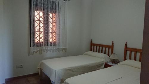 um quarto com duas camas e uma janela em PRECIOSO APARTAMENTO JUNTO AL MAR em Isla Canela