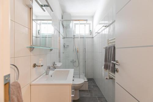 biała łazienka z umywalką i toaletą w obiekcie Apartments Tina Stinjan w Puli