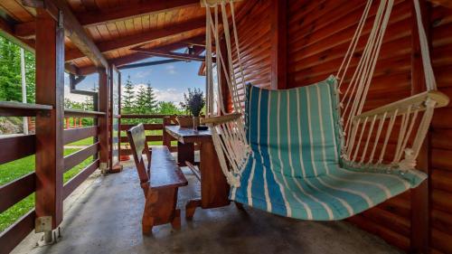 a porch with a hammock in a log cabin at Chalet Woody in Stara Sušica