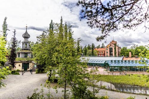 a view of a building with a tree in the foreground at Ramme Fjordhotell - Unike Hoteller in Hvitsten