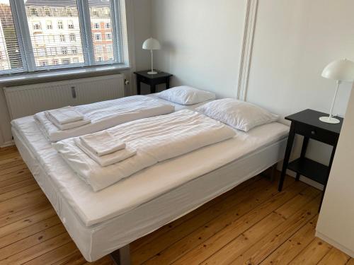 - un lit blanc avec des draps et des oreillers blancs dans l'établissement Lovely and homey Apartment at Frederiksberg, à Copenhague