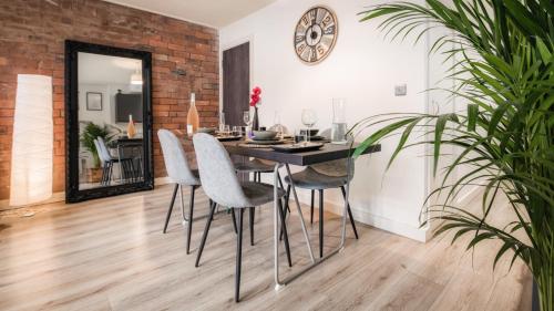 a dining room with a table and chairs at Stunning 2 bed with outside balcony, super king beds and 75’’ TV! in Bradford