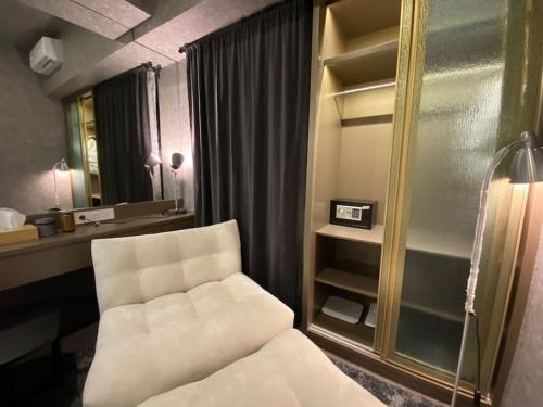 a living room with a white chair and a mirror at Casanty at Benson Apartment in Lontar