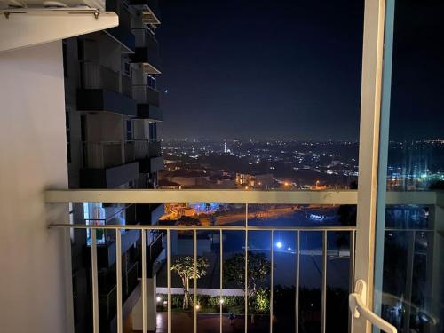 a view of a city at night from a balcony at Casanty at Benson Apartment in Lontar