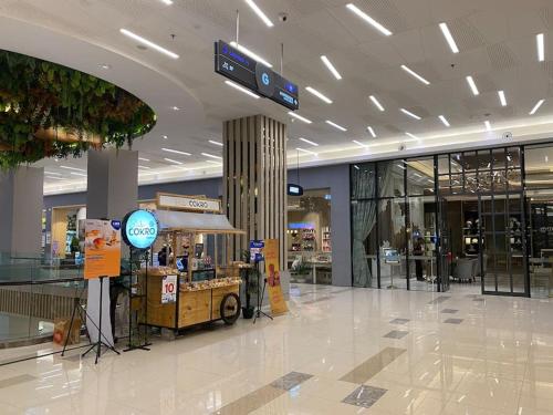 a shopping mall with a food cart in the middle at Casanty at Benson Apartment in Lontar
