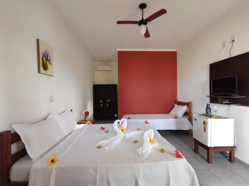 a bedroom with two swans on a bed at Pousada Costa do Sol in Canavieiras