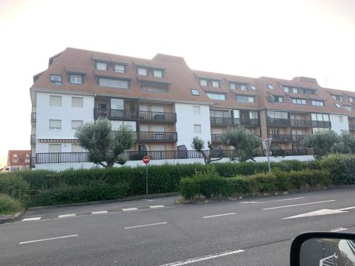 un gran edificio de apartamentos en el lateral de una calle en Petit appartement cosy en Villers-sur-Mer