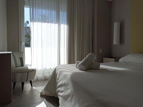a bedroom with a white bed and a large window at Vizion Suites by D&G in Carilo