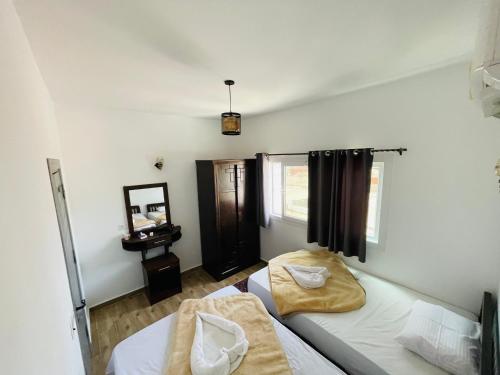 a bedroom with two beds and a mirror at Elite Residence Dahab in Dahab