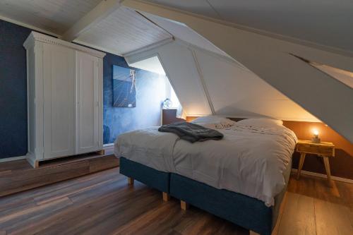a bedroom with a large bed with an attic at De Tweede Brug in Echten