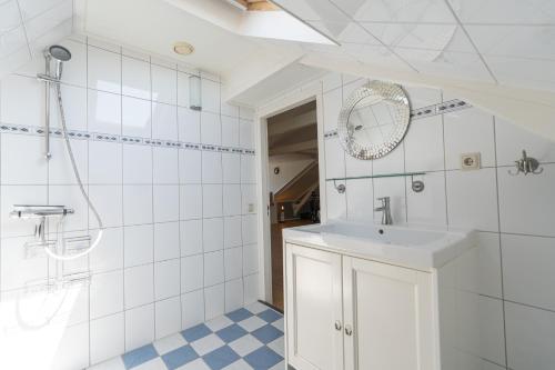 een witte badkamer met een wastafel en een spiegel bij De Tweede Brug in Echten