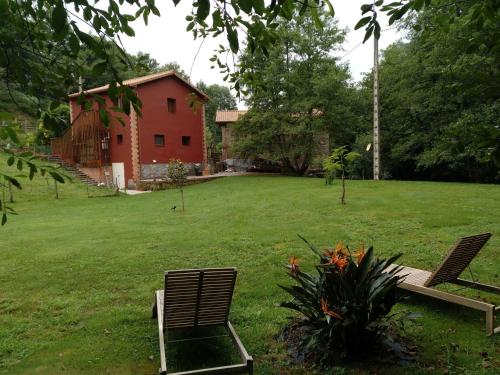 two chairs sitting in a yard with a house at Posada Pet Friendly El Molino de Cantabria in Entrambasaguas