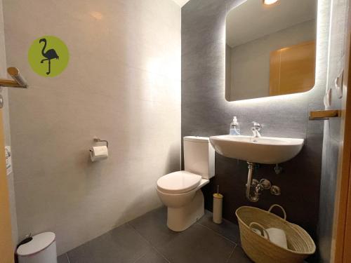 a bathroom with a toilet and a sink and a mirror at Apartamentos Los Flamencos in Daimiel