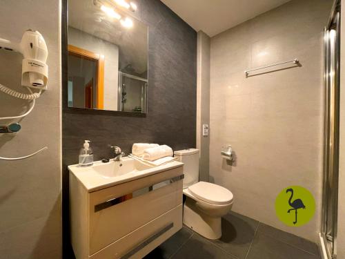 a small bathroom with a toilet and a sink at Apartamentos Los Flamencos in Daimiel