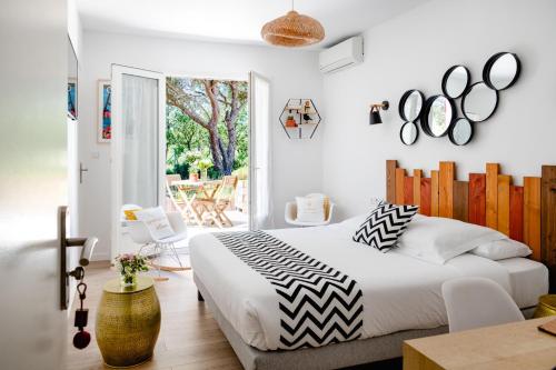 een slaapkamer met een groot bed en een patio bij Les Volets Rouges - Hôtel Cassis - Situé dans le Parc National des Calanques - Parking Gratuit in Cassis