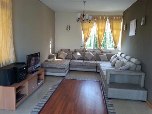 a living room with a couch and a tv at Krishangel Beach Apartment in Flic-en-Flac