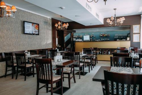 a dining room with tables and chairs and a bar at Penzion MartInn in Martin