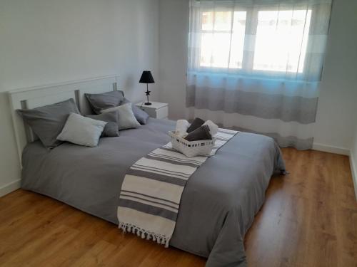 um quarto com uma cama com um cobertor e uma janela em Appartement 3 chambres sur la presqu'île de Peniche Portugal em Peniche