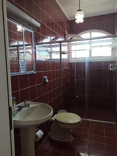 a bathroom with a toilet and a sink and a shower at Hostel na Rota da Serra Gaúcha in Taquara