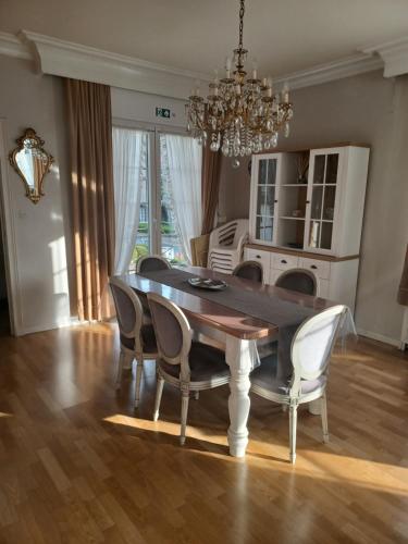einen Esstisch mit Stühlen und einem Kronleuchter in der Unterkunft Villa Elsjes Droom in Koksijde