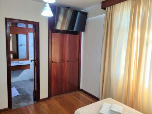 バルバセーナにあるLucape Palace Hotelのベッド1台、ドア、窓が備わる客室です。