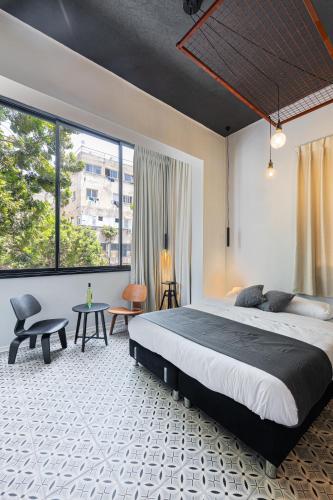 a bedroom with a large bed and a large window at Levinski Market Hotel in Tel Aviv