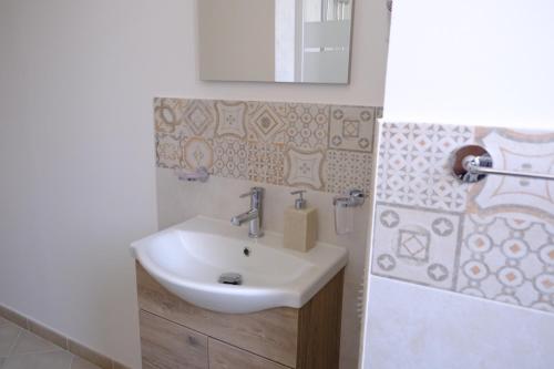 ein Badezimmer mit einem weißen Waschbecken und einem Spiegel in der Unterkunft Casa Beatrice Affittacamere - Dante in Palermo