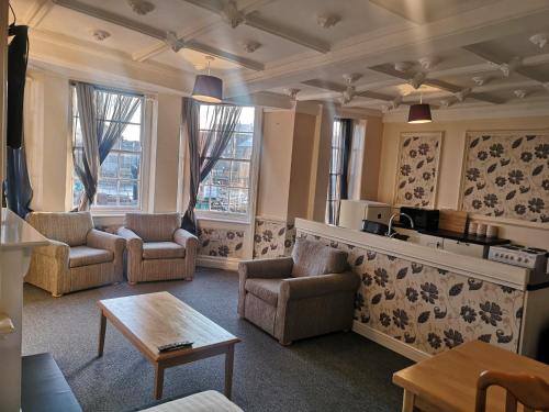 a living room with chairs and a table at Penthouse Flat with River View, 1C in Great Yarmouth