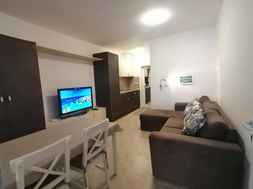 a living room with a couch and a flat screen tv at Belisima 204 B in Ravda