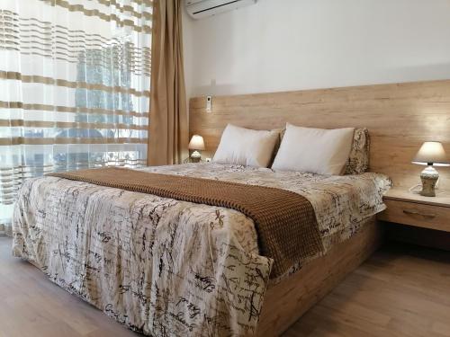 a bedroom with a large bed and a window at Belisima 204 B in Ravda
