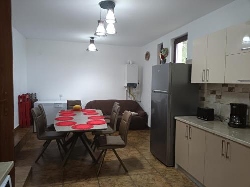 a kitchen with a table with chairs and a refrigerator at Casa Berbec in Dealul Viei