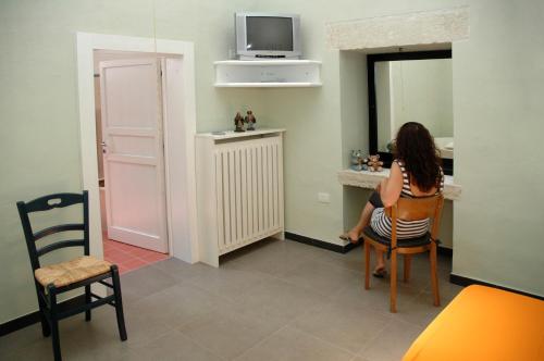 a woman sitting at a table in a room at B&B di Pino Conte in Serrano
