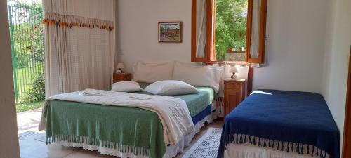 Tempat tidur dalam kamar di Pousada Asa do Vento