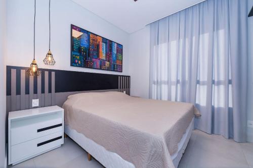 a bedroom with a white bed and a white dresser at Adra 306 - Excelente Cobertura Duplex - Centro/Bombinhas- Rooftop com Piscina - À poucos metros da praia - (Consultar serviços de roupas de cama e banho) in Bombinhas