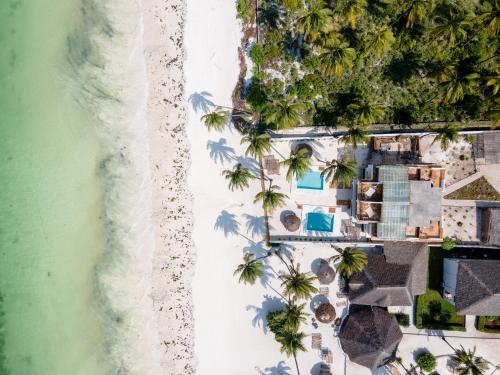 an aerial view of a resort with palm trees and the beach at Coco Rise Villas - by Hostly in Bwejuu