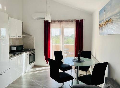 kuchnia ze stołem i krzesłami w pokoju w obiekcie Apartman Tina w mieście Murvica