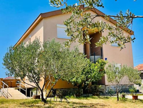 duży budynek z drzewami przed nim w obiekcie Apartman Tina w mieście Murvica
