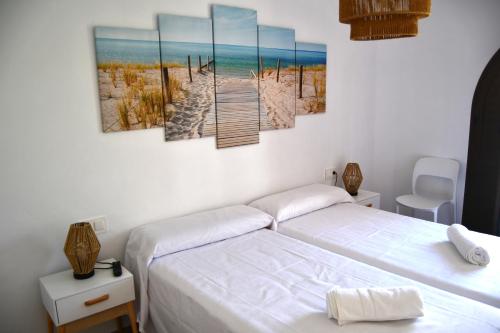 a bedroom with two beds and a boardwalk to the beach at Casa VALOLI PLAYA MIRAMAR in Miramar