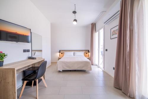 a bedroom with a bed and a desk with a chair at Ciuri' Affittacamere in Alcamo