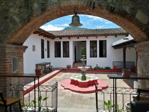 un arco que conduce a una casa con patio en Hostel Hopa Antigua, en Antigua Guatemala