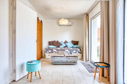 - un salon avec un lit et deux chaises dans l'établissement La Maison des Oliviers - Belle maison familiale avec Piscine, à Occhiatana