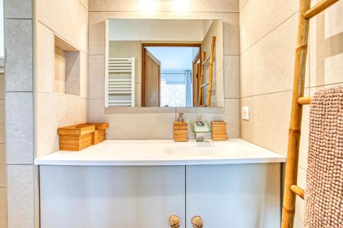une salle de bain avec un lavabo et un miroir dans l'établissement La Maison des Oliviers - Belle maison familiale avec Piscine, à Occhiatana