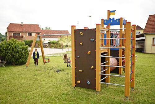 a man and a child playing on a playground at Penzion Rozárka in Přísečná