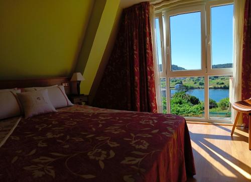 ア・コルーニャにあるCasa Mar de Ardoraのベッドと大きな窓のある寝室