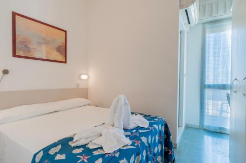 a bedroom with a bed with white towels on it at Hotel Montmartre in Rimini