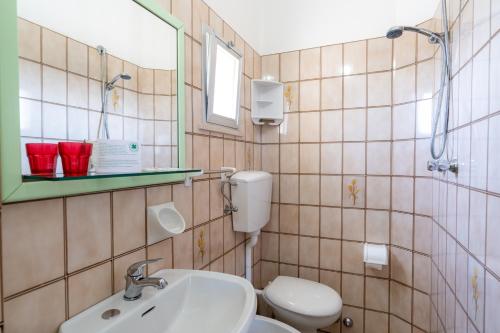 a bathroom with a toilet and a sink and a mirror at Hotel Montmartre in Rimini