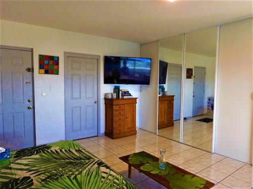 uma sala de estar com uma televisão de ecrã plano na parede em TAHITI - Studio Te Maraamu em Faaa